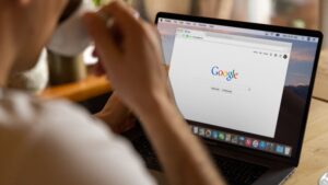 Pessoa pesquisando no Google em notebook sobre como aparecer no Google com estratégia de SEO