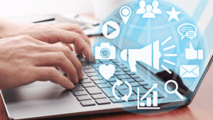 Profissional trabalhando no notebook com ícones de comunicação integrada ao redor da tela.